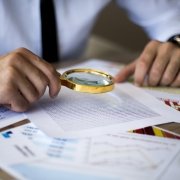using magnifying glass to conduct background checks