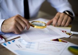 using magnifying glass to conduct background checks