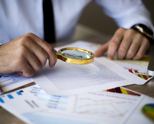 using magnifying glass to conduct background checks