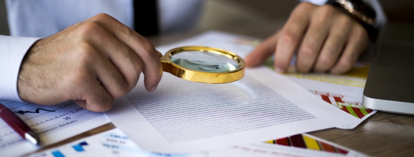 using magnifying glass to conduct background checks