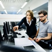 two professionals in office consulting on computer