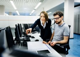 two professionals in office consulting on computer