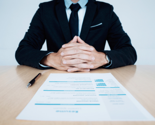 HR and resume of applicant undergoing background check and interview on table.