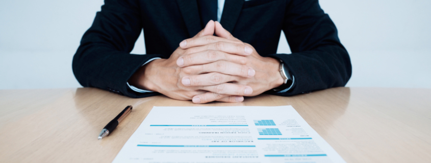 HR and resume of applicant undergoing background check and interview on table.