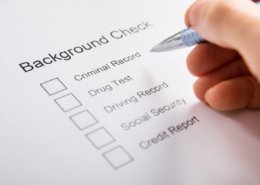 Close-up Of Person Hand Filling Background Check Provider Form