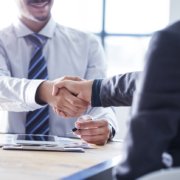 Cropped shot of two men shaking hands in background checking service