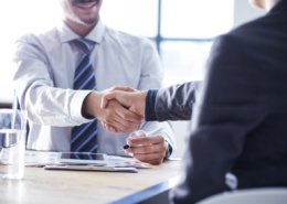 Cropped shot of two men shaking hands in background checking service