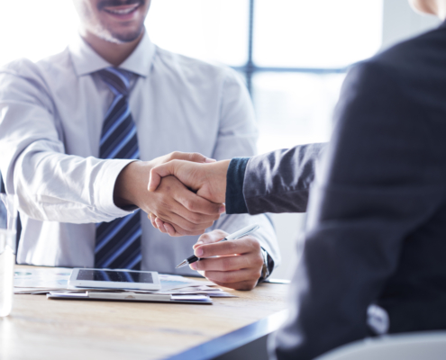 Cropped shot of two men shaking hands in background checking service