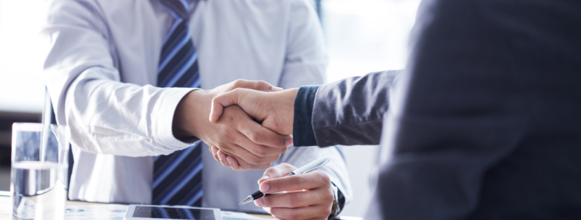 Cropped shot of two men shaking hands in background checking service