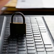 Computer keyboard and padlock as a symbol of network admin preforming principle of least privilege