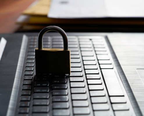 Computer keyboard and padlock as a symbol of network admin preforming principle of least privilege