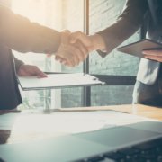Interview process begun as two men shake hands, and background check completed with credit report