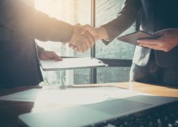 Interview process begun as two men shake hands, and background check completed with credit report