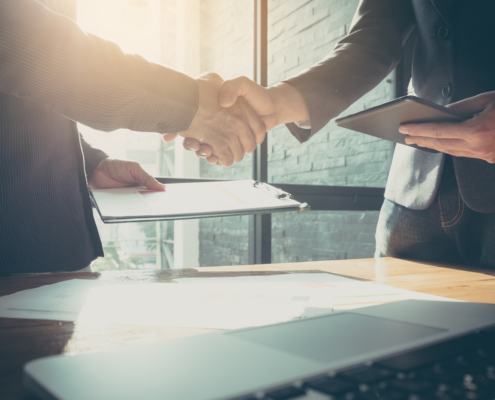 Interview process begun as two men shake hands, and background check completed with credit report