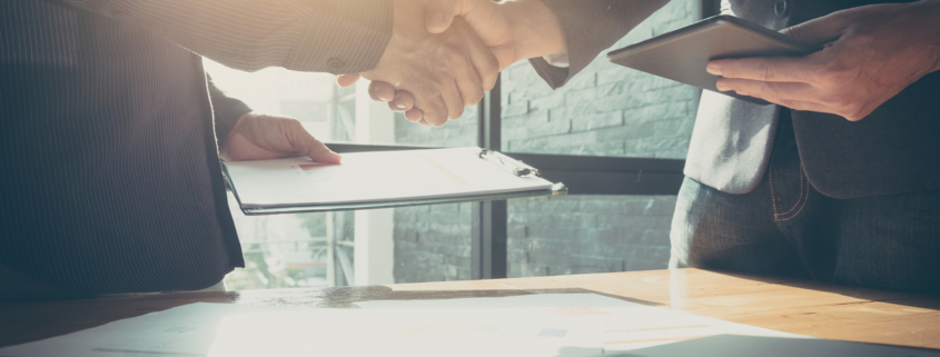 Interview process begun as two men shake hands, and background check completed with credit report