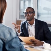 Male manager interviewing a seasonal employee after background screening her to avoid internal theft.
