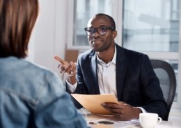 Male manager interviewing a seasonal employee after background screening her to avoid internal theft.