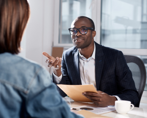 Male manager interviewing a seasonal employee after background screening her to avoid internal theft.