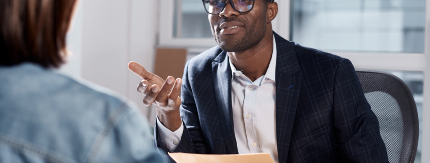 Male manager interviewing a seasonal employee after background screening her to avoid internal theft.