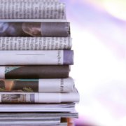 Stack of newspapers with negative headlines