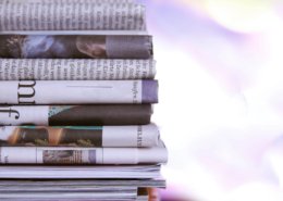 Stack of newspapers with negative headlines