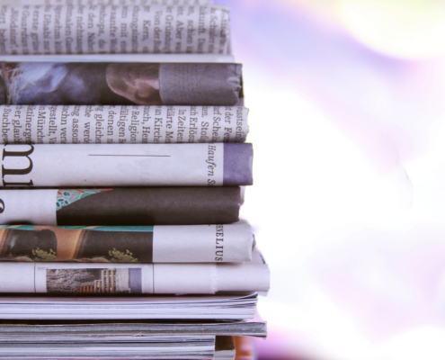 Stack of newspapers with negative headlines