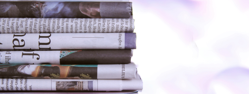Stack of newspapers with negative headlines