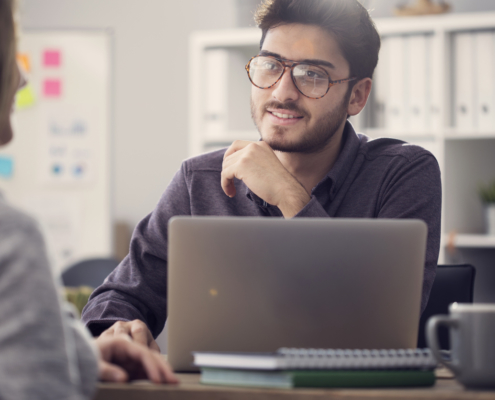 Young man interviewing at an office after NAPBS background compliance was met