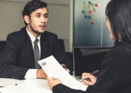Human resource manager interviewing the male employment candidate in the office room after background checks