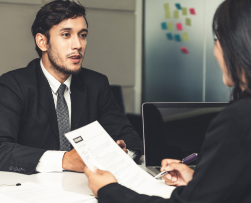 Human resource manager interviewing the male employment candidate in the office room after background checks