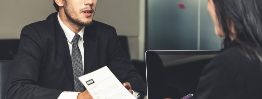 Human resource manager interviewing the male employment candidate in the office room after background checks