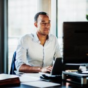 An office worker using working at his desk using a computer to user experience.