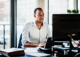 An office worker using working at his desk using a computer to user experience.
