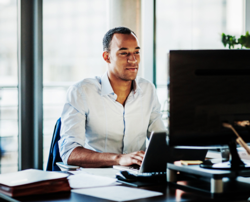 An office worker using working at his desk using a computer to user experience.