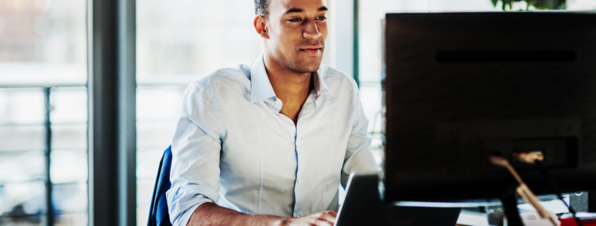 An office worker using working at his desk using a computer to user experience.